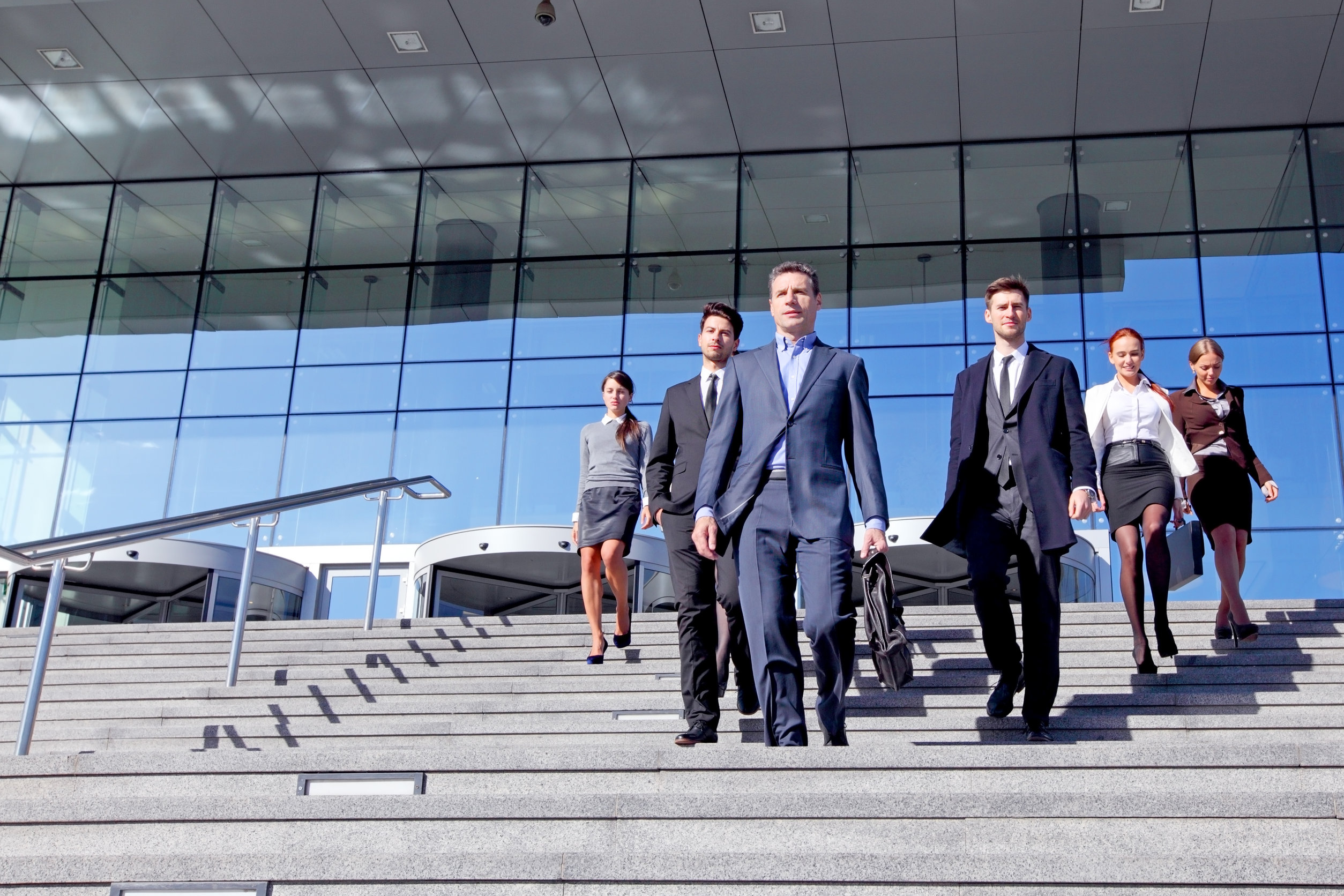 Business professionals walking down office building steps