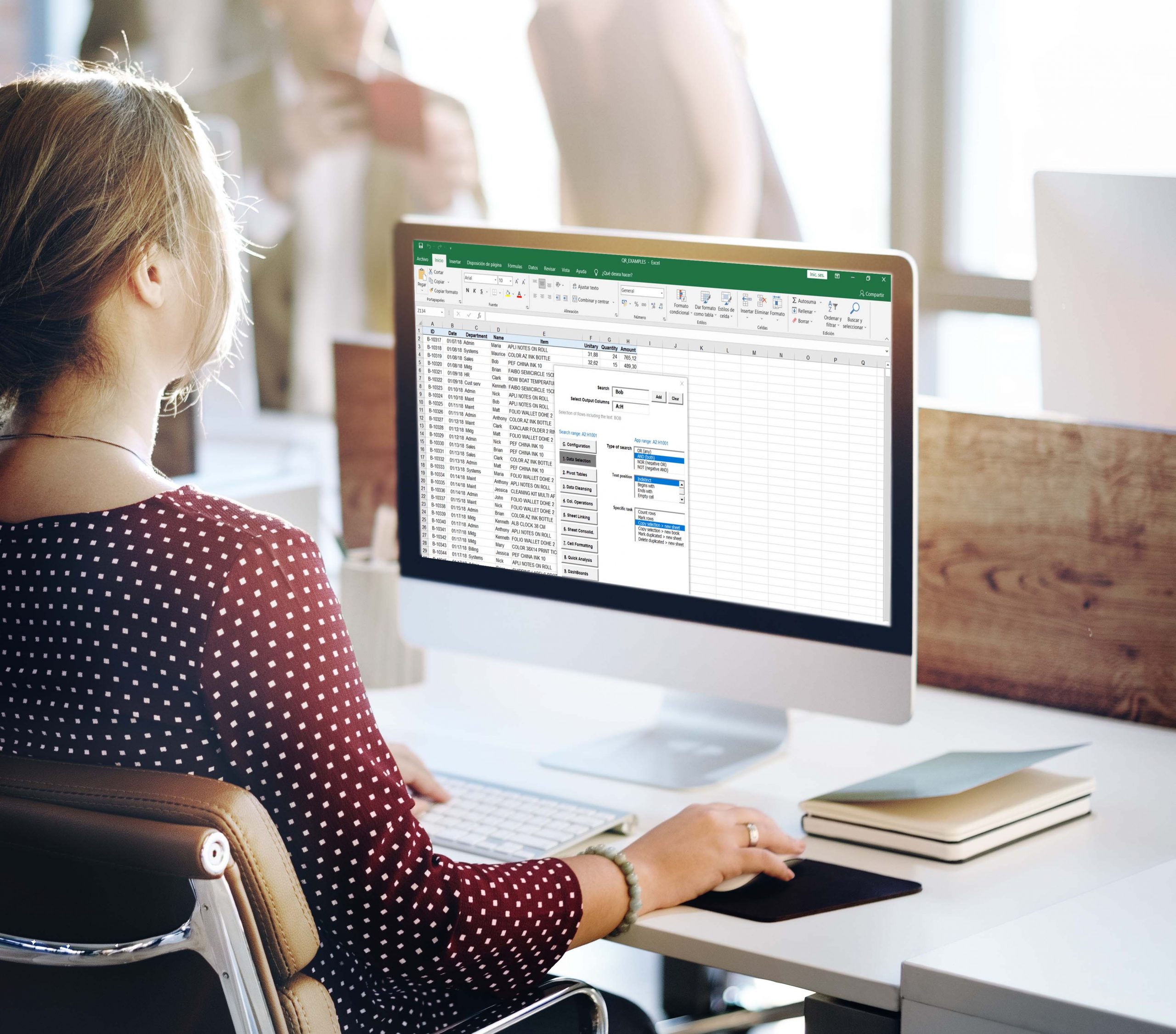 Woman working on spreadsheet on computer in office.