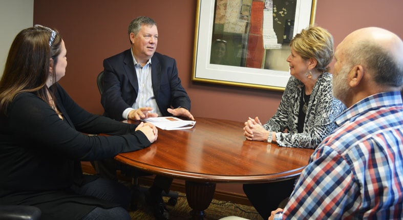 Four professionals discussing in a meeting room.