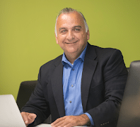 Smiling professional man with laptop in office setting.