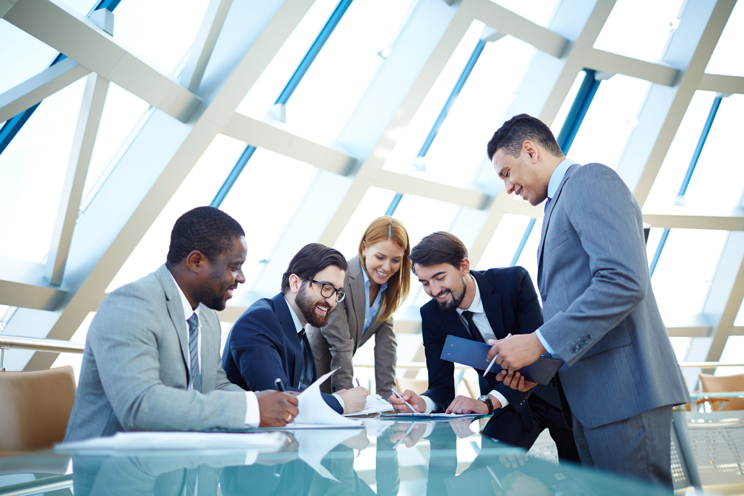 Business team discussing work at glass table.