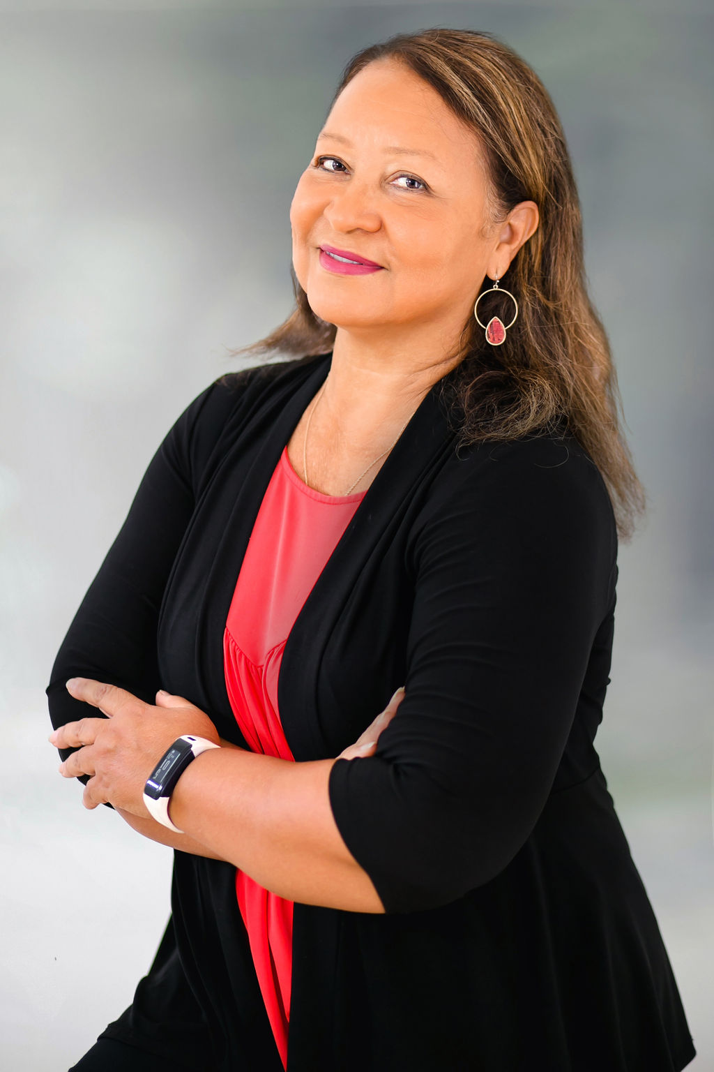 Confident businesswoman smiling in red and black attire.