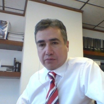 Man in office wearing white shirt and striped tie.