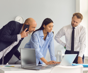 Colleagues collaborating on laptop in office meeting