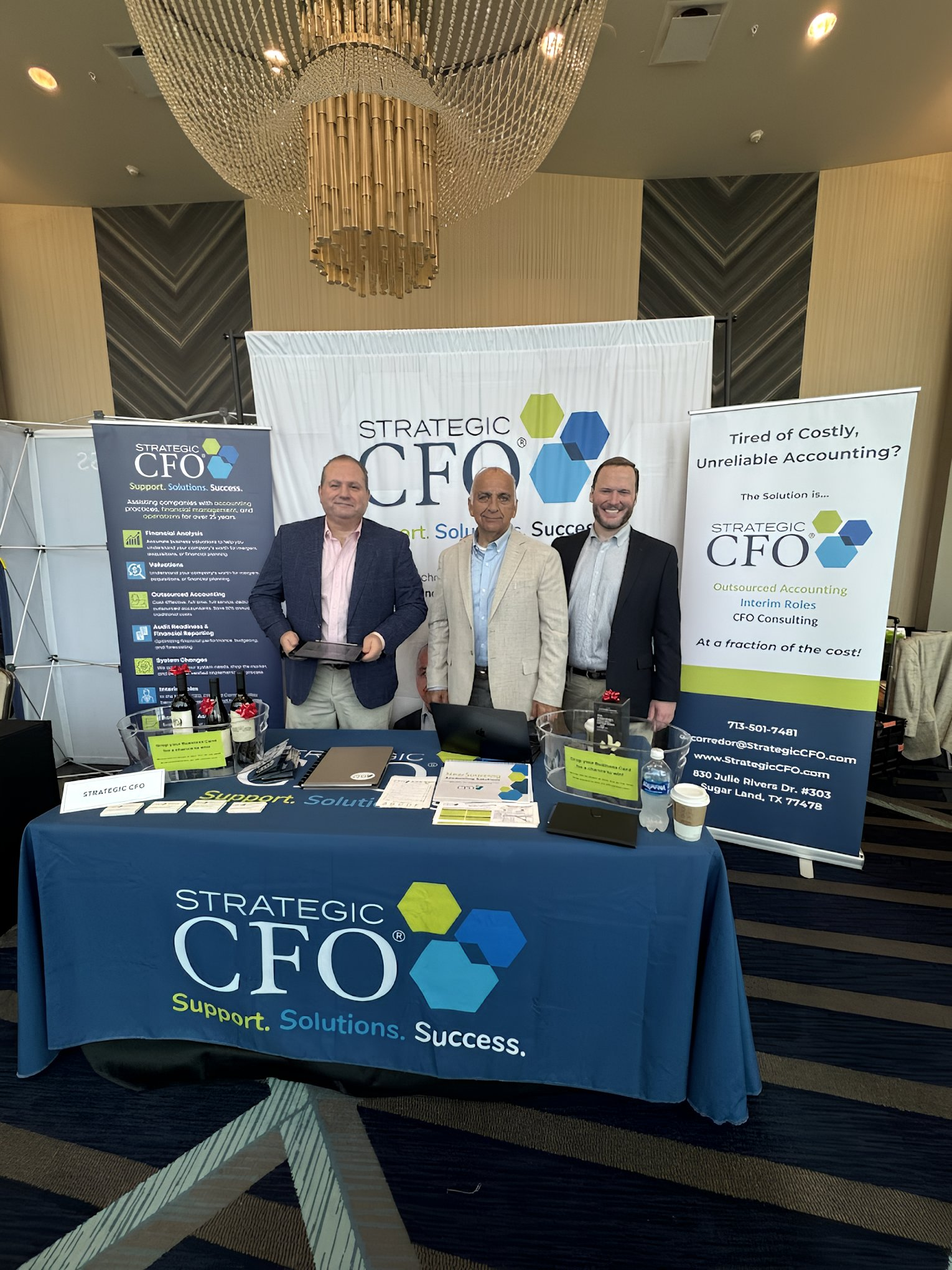 Strategic CFO booth with three people at event.