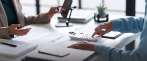Business meeting with calculator and smartphone