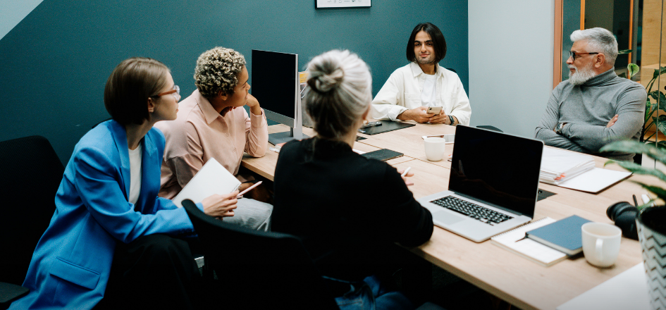 Team meeting around conference table with laptops