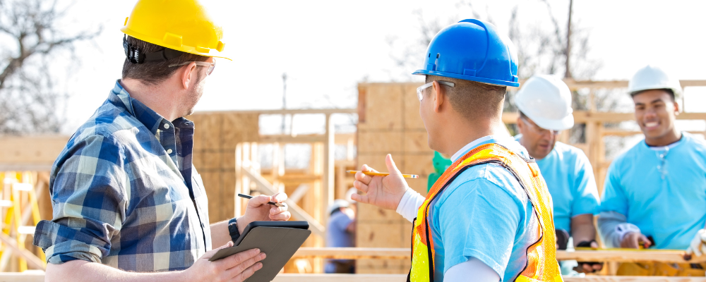 Construction workers discussing plans at building site