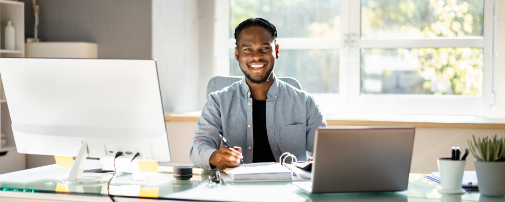 Smiling man working at desk in bright office