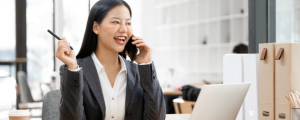 Smiling businesswoman talking on phone at desk