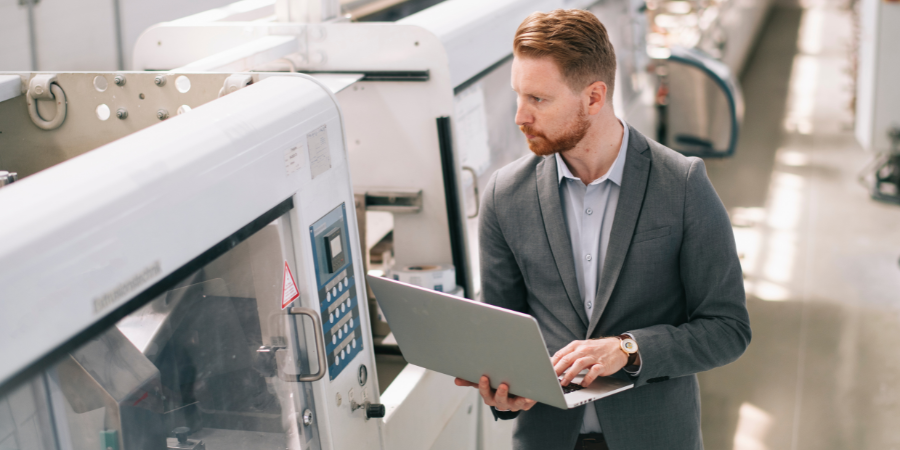 Manufacturing executive reviewing production and financial data for outsourced accounting