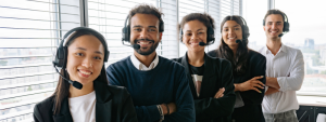 Five smiling Outsourced Accounting Team agents wearing headsets